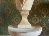 a statue of a man in a tuxedo on top of a pedestal