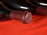 several bottles of wine are lined up on a red cloth