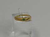 an image of a gold ring with a green stone on it