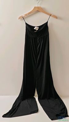 une robe noire sur un cintre, près d'un mur blanc