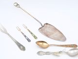 many spoons and forks that are sitting on a table
