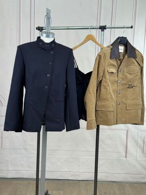 two jackets on a stand next to each other