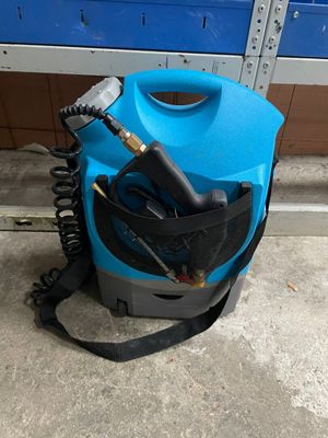 un sèche-cheveux bleu posé par terre à côté d'un mur bleu