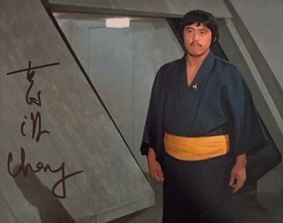 une photo d'un homme en kimono debout devant un mur