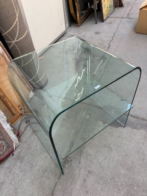 une table en verre avec un plateau en verre posée sur le trottoir