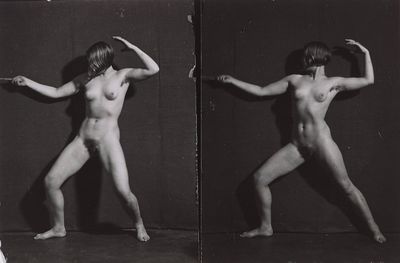 black and white photograph of a naked woman posing in front of a mirror