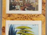 deux tableaux encadrés représentant une ville et un arbre, dans un cadre en bois