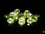 some very pretty green crystal beads on a black surface