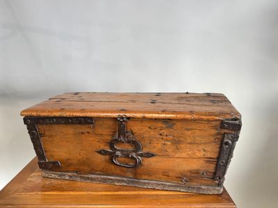 une vieille malle en bois posée sur une table en bois