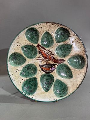 une assiette verte avec un oiseau dessiné dessus, posée sur une table
