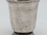 an antique silver cup on a pedestal on a white background