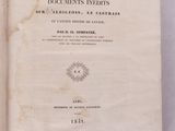 un vieux livre posé sur une table à côté d'un mur blanc