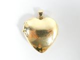 une image représentant un pendentif doré en forme de cœur sur fond blanc