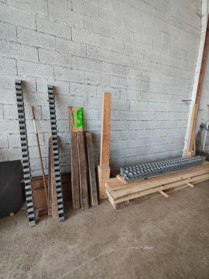 Plusieurs morceaux de bois sont empilés sur une palette, à côté d'un mur de briques