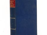 an old book with a blue cover sitting on top of a table