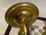 a gold candle holder on a table with a checkered table cloth