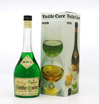 des bouteilles de vin et une boîte de verres à vin posés sur une surface blanche
