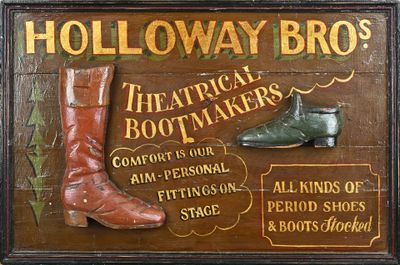 une pancarte en bois sur laquelle est représentée une paire de bottes