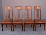 quatre chaises en bois avec des assises recouvertes de cuir dans une pièce