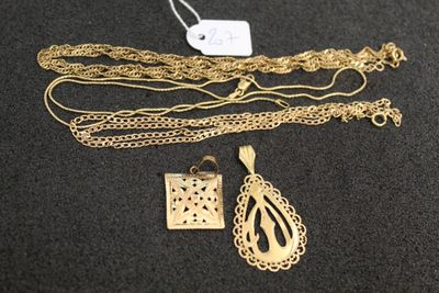 un gros plan sur un collier en or et d'autres bijoux posés sur une surface noire