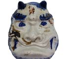a ceramic figurine of a face with blue and white paint