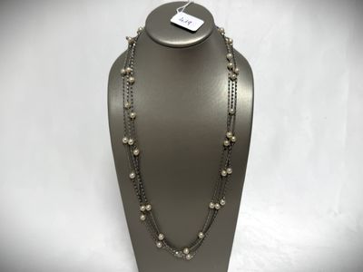 a necklace with pearls and chains on a mannequin