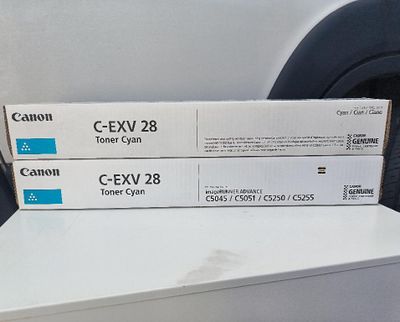 deux boîtes de cartouches de toner Canon C-EXV 28 posées sur une étagère