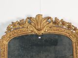 a mirror with a gold frame hanging on a wall