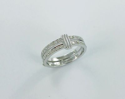 a close up of a diamond ring on a white surface