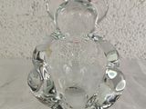 a glass teddy bear sitting on top of a glass plate