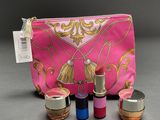 a close up of a pink bag with lipstick and other items