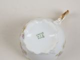 an image of a white porcelain tea pot with a gold handle
