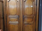 a large wooden armoire in the corner of a room