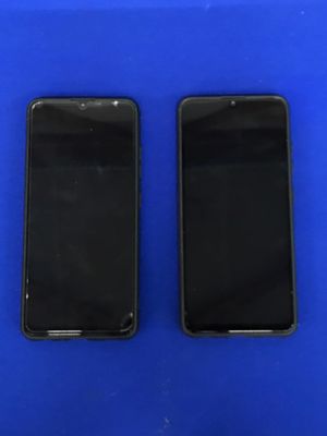 deux iPhones noirs posés côte à côte sur une surface bleue