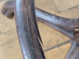 a close up of a wooden chair on a brick floor