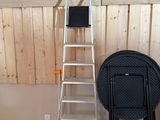 une échelle appuyée contre un mur, à côté d'une chaise