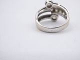 a silver ring with a diamond in it on a white surface
