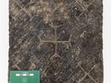 a close up of a piece of stone with a cross on it