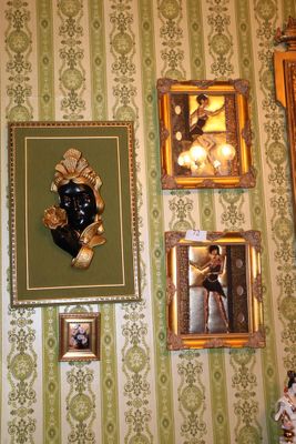 many pictures on the wall of a room with a clock