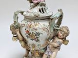 a small vase with a statue on top of it