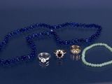 un collier de perles bleues orné d'une bague, d'un bracelet et d'une bague