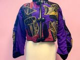purple and black jacket on a mannequin stand against a pink wall
