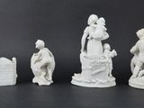 several white figurines of people and animals on a black surface