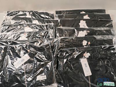 many bags of black clothing sitting on a table