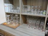 de nombreux verres et bouteilles sur les étagères de la pièce
