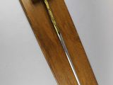 a wooden plaque with a sword hanging on the wall
