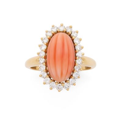 BAGUE ornée d'un corail ovale godronné dans un entourage de …