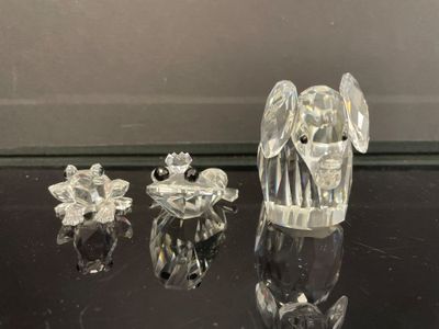 figurines en cristal représentant des anges et des fleurs, posées sur une table noire