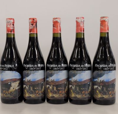 quatre bouteilles de vin posées sur une table, l'une à côté de l'autre