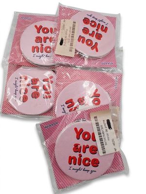 trois boutons roses sur lesquels est inscrit « tu es gentil »